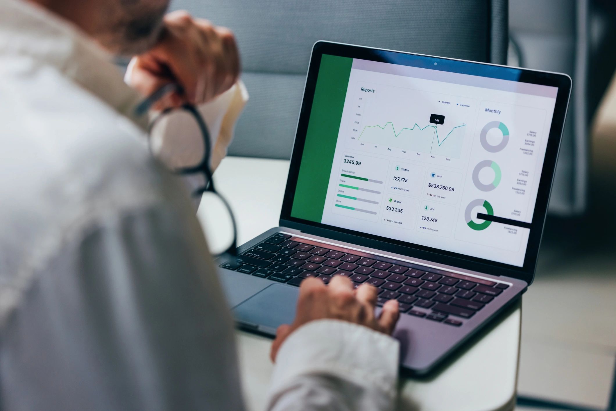 Professional reviewing financial charts on a laptop